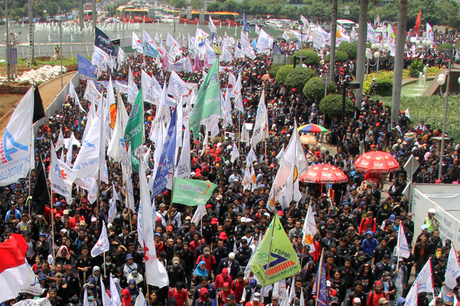 Ribuan buruh berunjuk rasa melintasi Jalan MH Thamrin menuju ke Istana Merdeka, Jakarta (12/02). Foto: RES