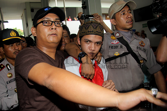 Agun Iskandar, terdakwa kasus JIS, memasuki ruang sidang dengan pengawalan ketat petugas, Selasa (26/8). Foto: RES
