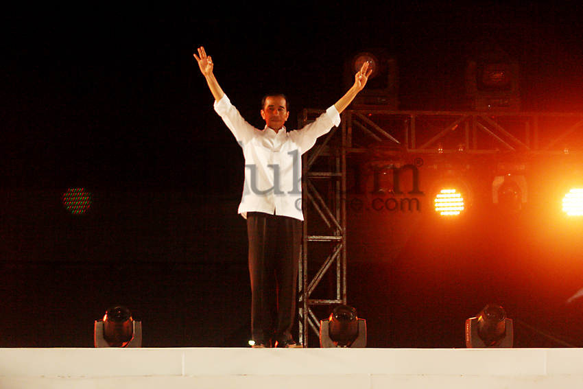 Presiden Joko Widodo menyapa masyarakat yang hadir dalam Pesta Rakyat di Silang Monas, Jakarta, Senin (20/10). Joko Widodo menyampaikan pidato pertamanya di depan relawan dan masyarakat.