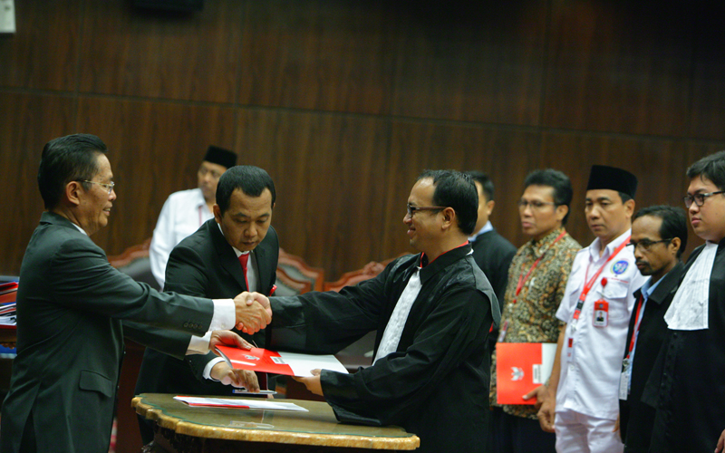 Panitera MK Kasianur Sidauruk saat memberikan salinan putusan kepada kuasa hukum Pemohon Andi Syafrani, Selasa (11/11). Foto: Humas MK