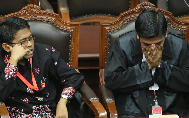 Pemohon Ahmad Suryono didampingi kuasanya saat menyimak pembacaan amar putusan perkara uji materi UU OJK, Selasa (4/8). Foto: Humas MK