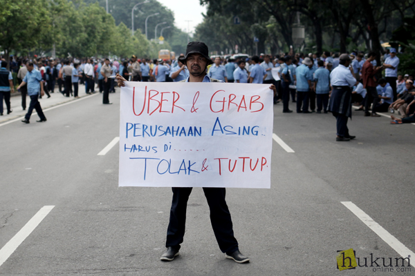 Ribuan pengemudi sejumlah armada taksi menggelar unjuk rasa di jalan Medan Merdeka Selatan, Jakarta, Senin (14/3). Mereka menuntut pemerintah menutup taksi berbasis online yang dinilai tidak sesuai dengan UU Lalu Lintas dan Angkutan Jalan. Foto: RES