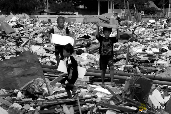 Beberapa bocah Luar Batang mengumpulkan barang-barang dari kumpulan sampah pasca penggusuran. Foto: RES