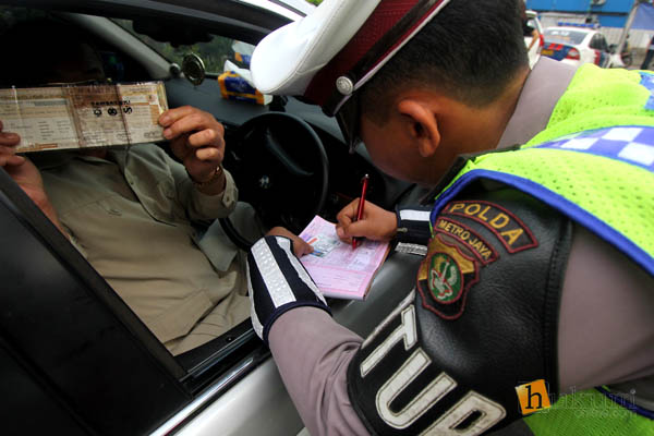Polisi memberhentikan dan memeriksa plat nomor mobil di kawasan pembatasan lalu lintas ganjil-genap di sekitar Bundaran Senayan, Jakarta, Selasa (30/8). FOTO: RES