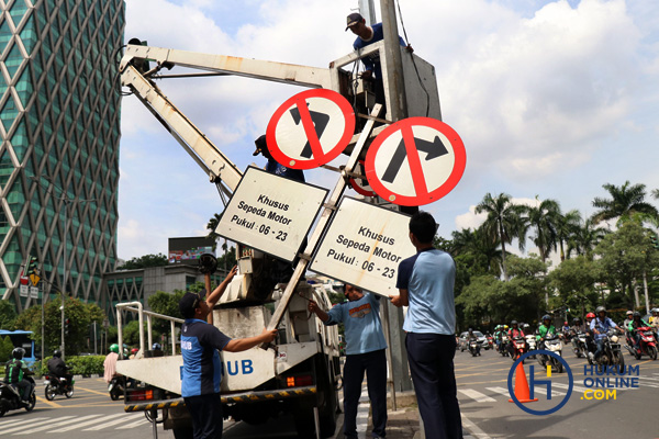 Petugas saat membongkar rambu larangan motor melintasi di Jl. MH Thamrin Jakarta Pusat. Foto: RES