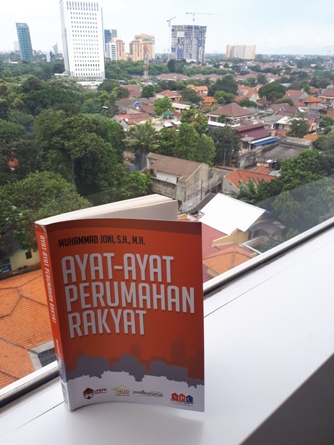 Buku 'Ayat-Ayat Perumahan Rakyat' dengan latar belakang rumah dan gedung-gedung di Jakarta. Foto: MYS