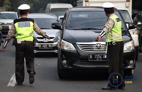 Petugas kepolisian dan Dinas Perhubungan menghalau kendaraan berplat nomor genap saat penerapan jalur Ganjil Genap di jalan Kartini, Jakarta Selatan, Rabu (1/8). Foto: RES