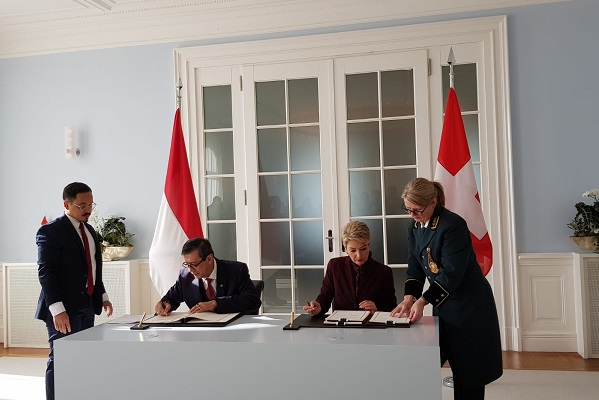Menkumham Yasonna H Laoly bersama Kepala Departemen Peradilan dan Kepolisian Federal Swiss Karin Keller Sutter saat menandatangani perjanjian MLA. Foto: Humas Kemenkumham