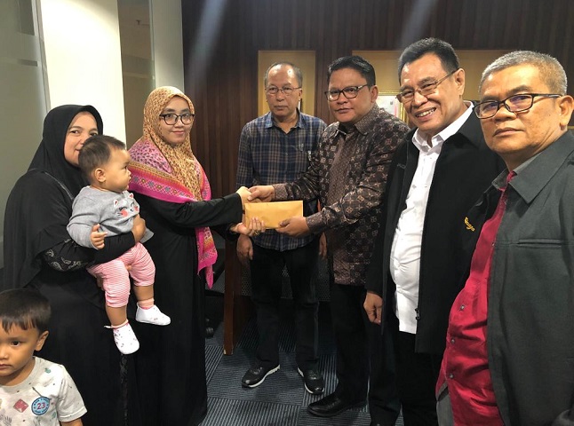 Rahmawati dan kedua anaknya, Keenan dan Nadhifa menerima santunan dari Wakil Sekretaris Jenderal DPN PERADI, Rivai Kusumanegara. Foto: Istimewa.
