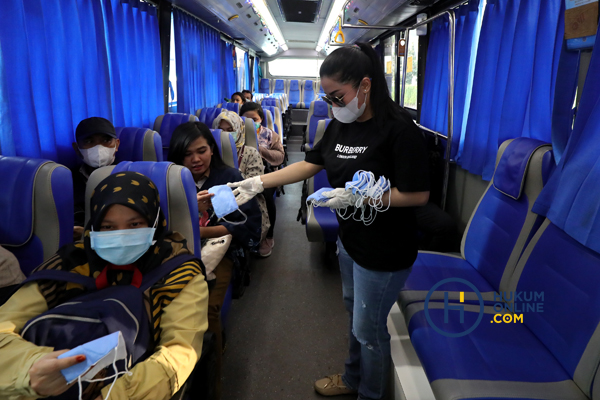Relawan membagi masker gratis kepada penumpang. Pemerintah alihkan anggaran untuk penanganan Covid-19. Foto: RES