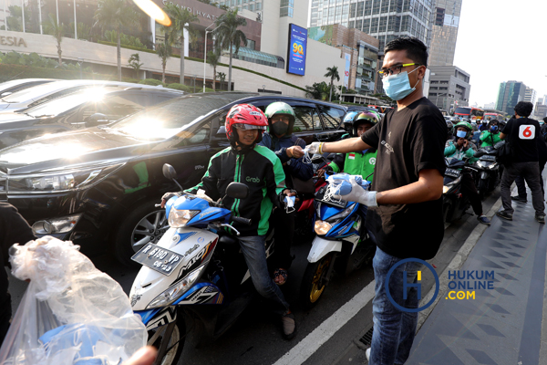 Beragam kelompok masyarakat dan profesi memberikan bantuan untuk mencegah penyebaran Covid-19, termasuk memberikan masker gratis kepada pengguna jalan. Foto: RES