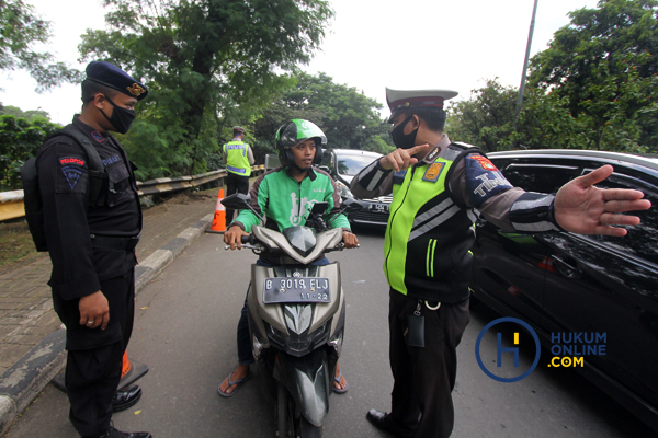 Polisi mengarahkan pengendara motor yang dijadikan ojek online, pada masa PSBB di Jakarta. Foto: RES