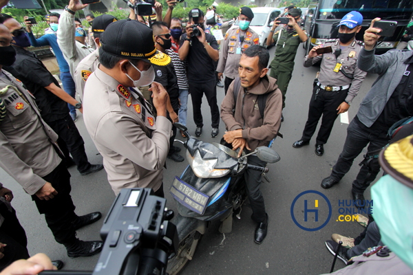 Petugas Kepolisian saat menertibkan masyarakat yang melanggar aturan PSBB di pos cek poin. Foto: RES