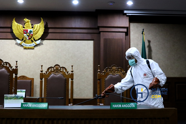 Petugas saat menyemprotkan disinfektan di ruang sidang pengadilan. Foto: RES