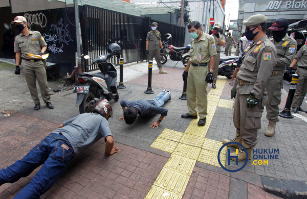 Petugas menghukum warga yang melanggar protokol kesehatan saat pelaksanaan PSBB Jakarta pada April lalu. Foto: RES 