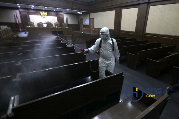 Petugas saat menyemprotkan disinfektan di ruang sidang pengadilan. Foto: RES