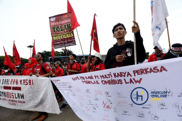 Gerakan Buruh Bersama Rakyat membentangkan atribut menolak Omnibus RUU Cipta Kerja saat menggelar aksi demonstrasi di depan Gedung DPR, Senin (13/1/2020) lalu. Foto: RES