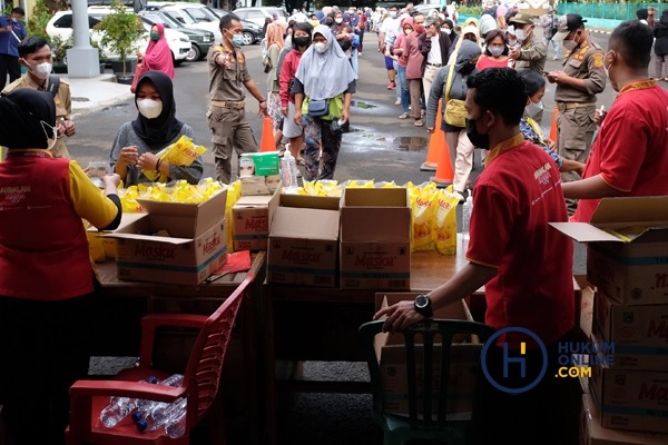 Sejumlah warga antre membeli minyak goreng kemasan saat operasi pasar minyak goreng murah di Halaman Kantor Kecamatan Pamulang, Tangerang Selatan, Sabtu (5/2/2022). Foto: RES