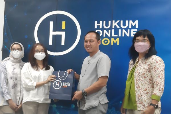 Editor in Chief Hukumonline Fathan Qorib didampingi Partnership and Community Manager Hukumonline Farah Purwaningrum (paling kanan) menyerahkan kenang-kenangan kepada perwakilan Tim Delegasi ALSA FHUI, Selasa (26/7/2022). Foto: NEE 