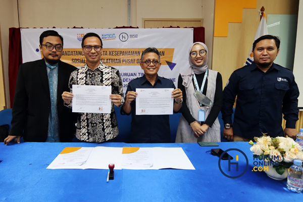 Chief Content Officer Hukumonline Amrie Hakim dan Ketua STIH IBLAM Dr. Gunawan Nachrawi (tengah) usai menandatangani MoU terkait program layanan University Solutions, Rabu (23/11/2022). Foto: RES 