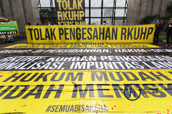 Gabungan sejumlah elemen masyarakat membentangkan spanduk menolak pengesahan RKUHP saat berunjuk rasa di depan Kompleks Parlemen, Senayan, Jakarta, Selasa (6/12/2022). Foto: RES