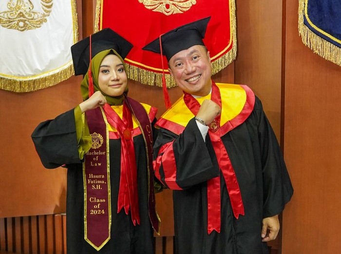 Haura Fatima (kiri) dan ayahnya, Ari Wahyudi Hertanto  saat wisuda bersama dari FHUI, Sabtu (2/3/2024). Foto: Humas UI