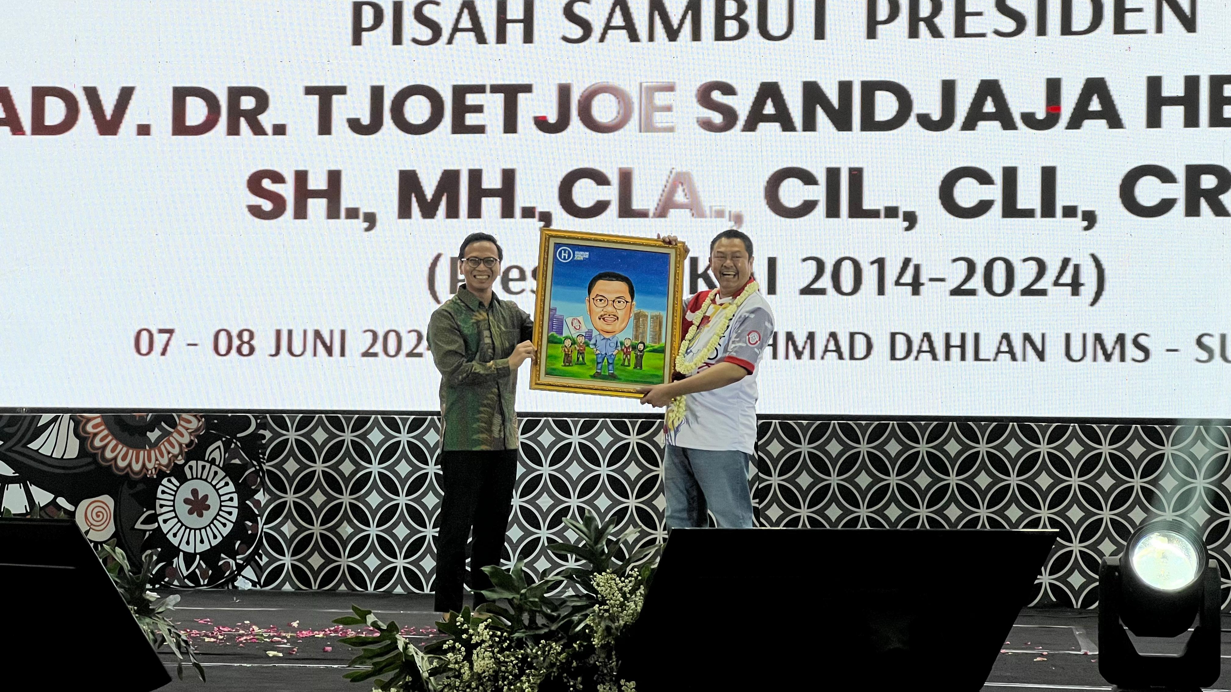 Penyerahan cendera mata berupa karikatur, oleh Chief Media & Engagement Officer Hukumonline, Amrie Hakim kepada Presiden Demisioner KAI, Tjoetjoe Sandjaja Hernanto. Foto: istimewa.