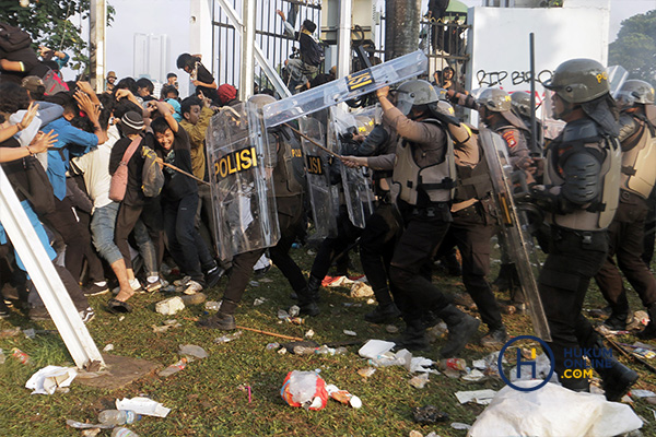 Aparat kepolisian saat menghadapi para demonstran di area lingkungan Gedung DPR saat demonstrasi penolakan RUU PIlkada. Foto: RES