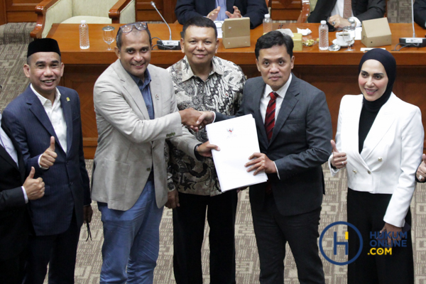 Wakil Menteri Hukum, Profesor Edward Omar Sharif Hiariej secara simbolis menyerahkan DIM RUU KUHAP kepada Ketua Komisi III Habiburokhman seusai menggelar rapat kerja, Selasa (8/7/2025). Foto: RES